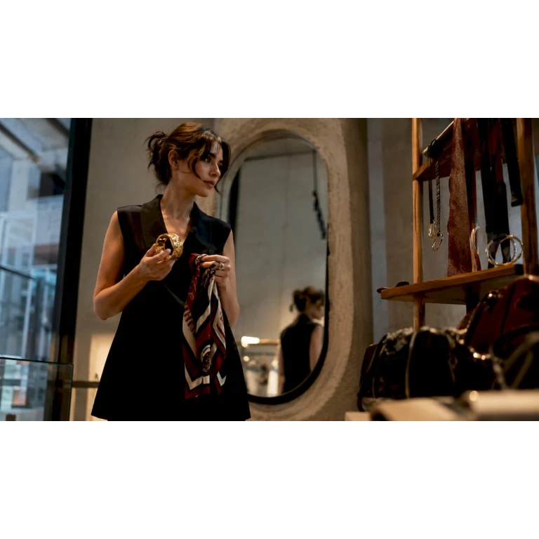 Een vrouw staat in de paskamer en twijfelt welke accessoires ze bij haar outfit wil dragen.