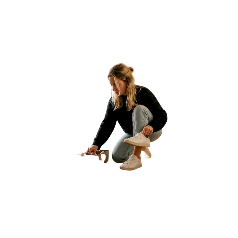 Een vrouw past binnenshuis een paar sneakers om te kijken of ze lekker zitten.