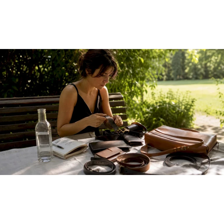 Une femme parcourt attentivement une sélection d’accessoires en cuir.